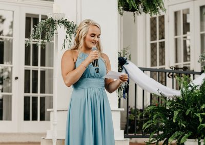 standing bridesmaid makes speech holding mic