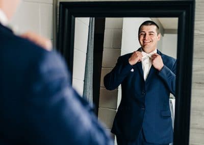 0158_Ludlow-Mansion-groom-fix-bow-tie-in-mirror
